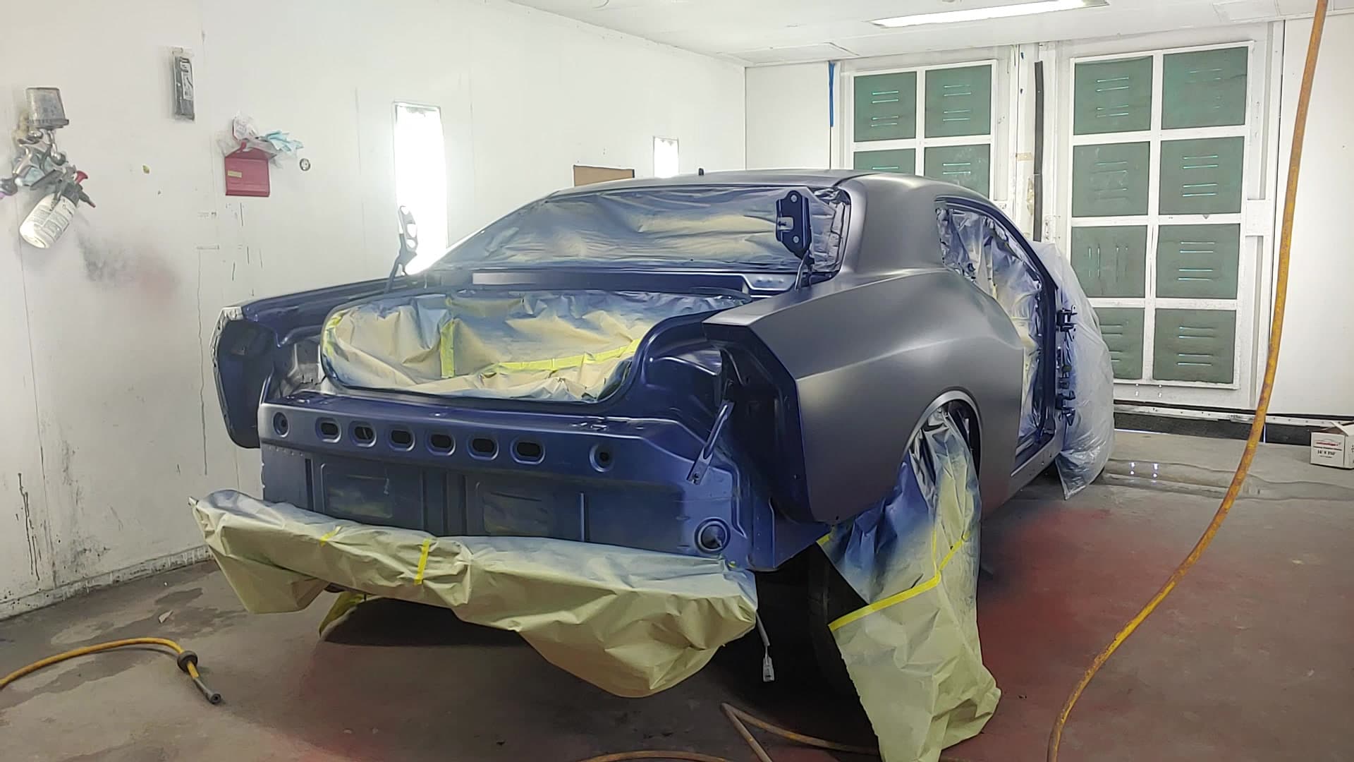 A second car in primer and masking film in the D&D Auto Body spray booth